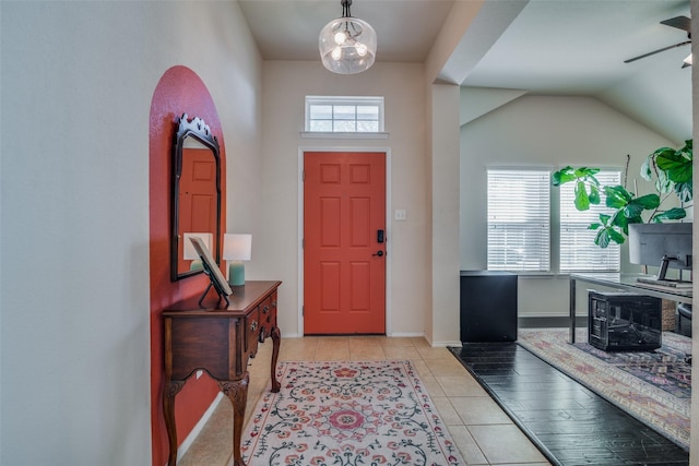 tiled foyer featuring a wealth of natural light, ceiling fan, and vaulted ceiling