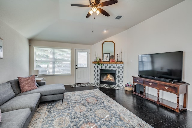 living room featuring a tile fireplace, lofted ceiling, ceiling fan, and dark hardwood / wood-style floors