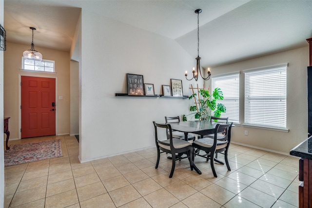 tiled dining space with a wealth of natural light, vaulted ceiling, and an inviting chandelier