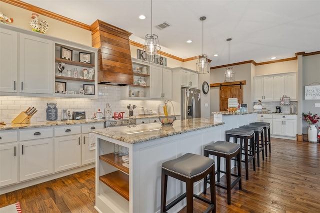 kitchen featuring light stone countertops, dark hardwood / wood-style flooring, stainless steel appliances, and a kitchen island