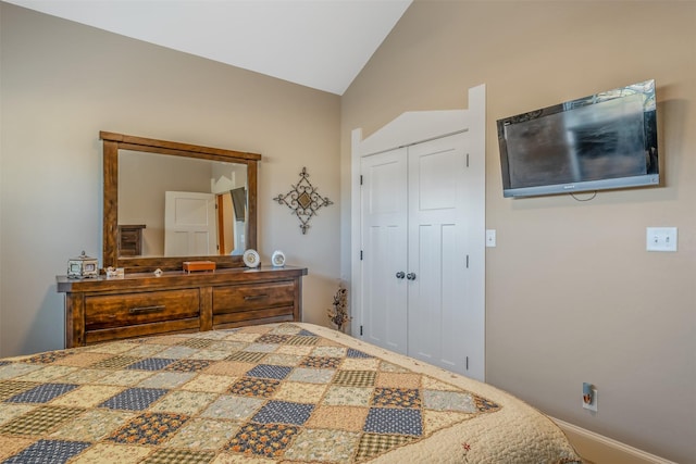 bedroom with vaulted ceiling and a closet