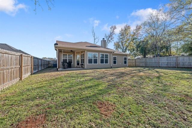 back of property with ceiling fan, a yard, and a patio