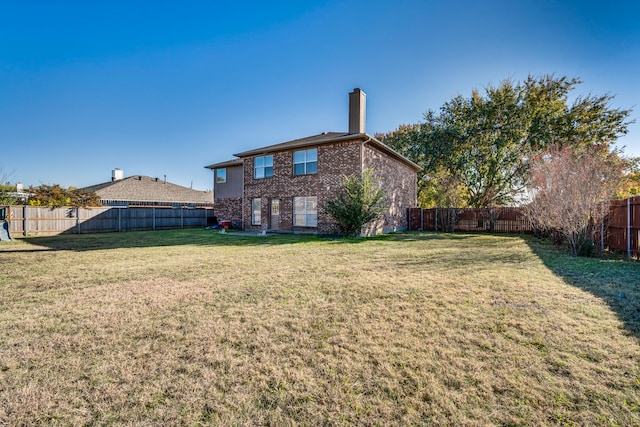 back of property featuring a lawn