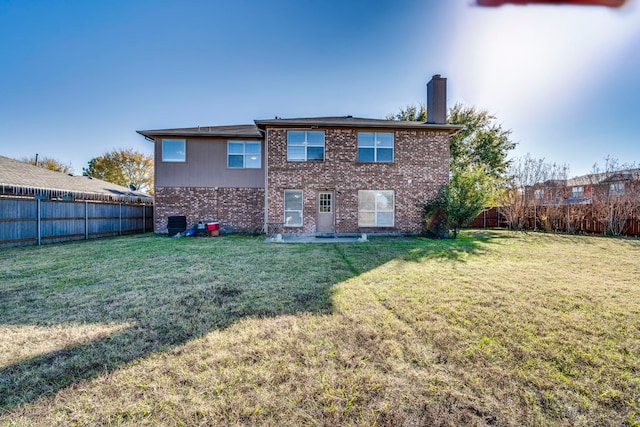 rear view of house with central AC and a yard