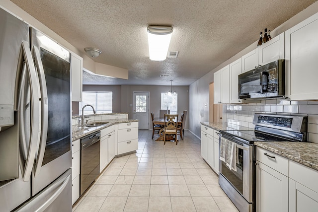 kitchen featuring backsplash, sink, black appliances, light tile patterned floors, and white cabinetry