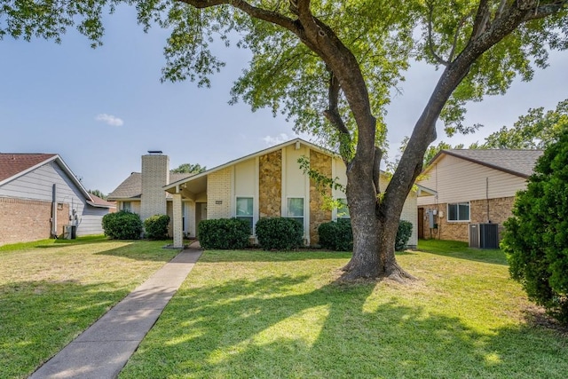 ranch-style house featuring a front lawn and central AC unit