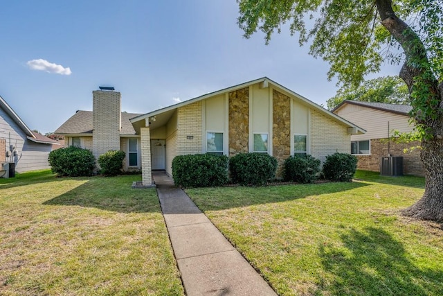 view of front of home with central AC unit and a front lawn