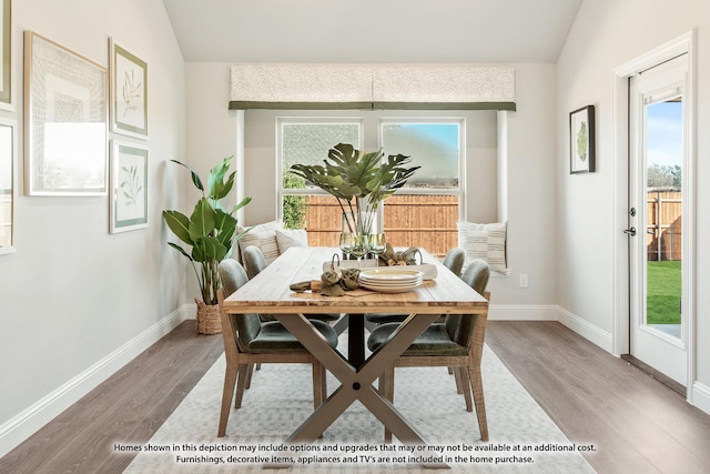 dining space with wood-type flooring and lofted ceiling