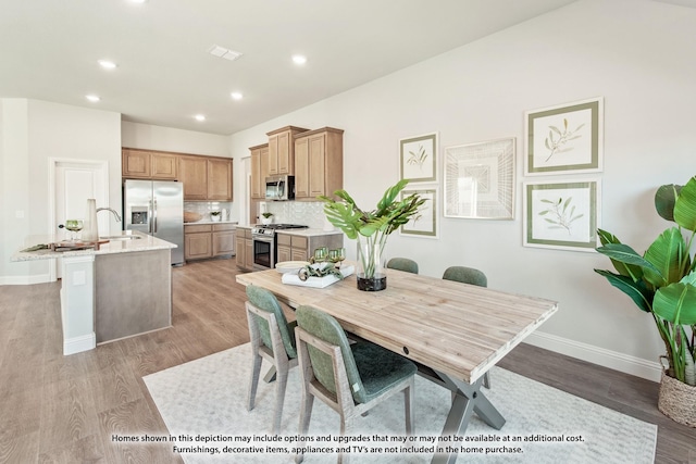 dining room with sink and light hardwood / wood-style flooring