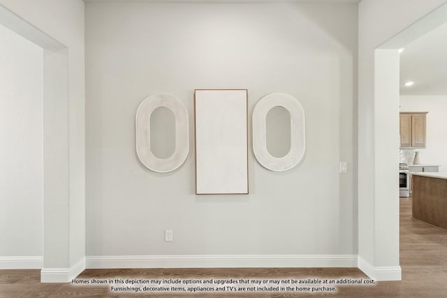 interior details with stainless steel electric range oven and hardwood / wood-style floors