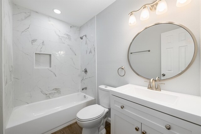 full bathroom with vanity, wood-type flooring, tiled shower / bath combo, and toilet