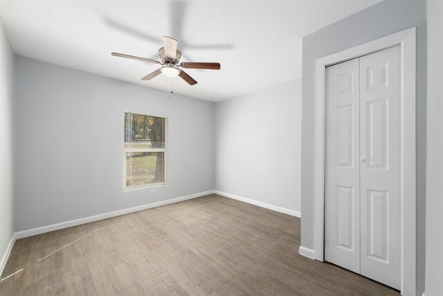 unfurnished bedroom with hardwood / wood-style floors, ceiling fan, and a closet