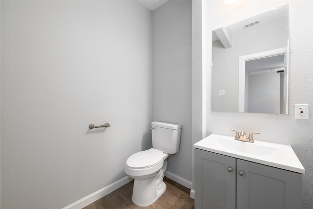 bathroom featuring vanity, hardwood / wood-style flooring, and toilet