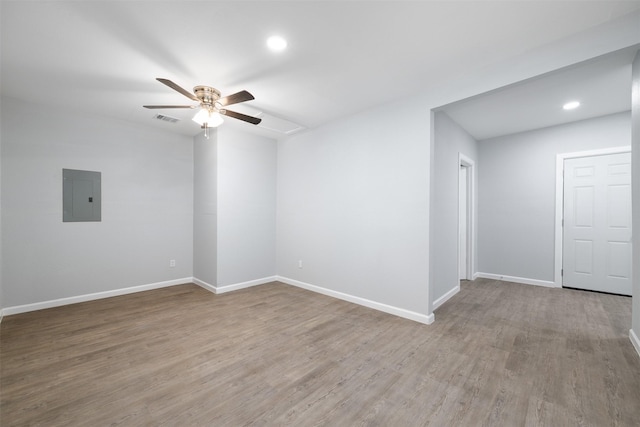 empty room with hardwood / wood-style floors, ceiling fan, and electric panel