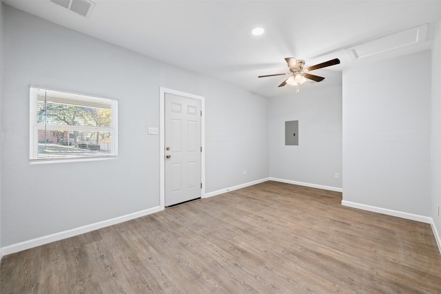 unfurnished room with hardwood / wood-style flooring, ceiling fan, and electric panel