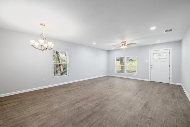 unfurnished living room with ceiling fan with notable chandelier and dark hardwood / wood-style flooring