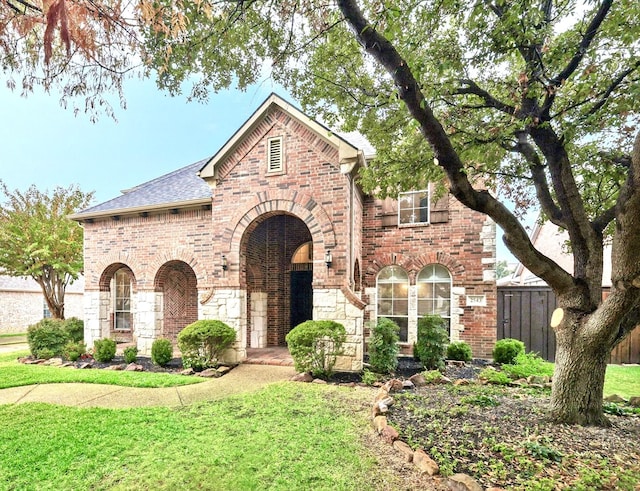 tudor-style house featuring a front lawn