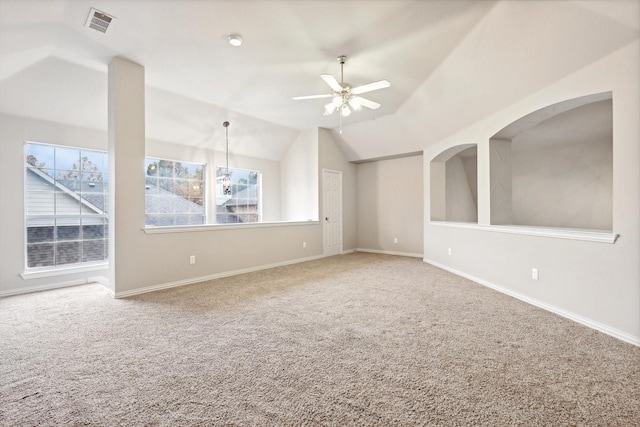 empty room with vaulted ceiling, ceiling fan with notable chandelier, and carpet