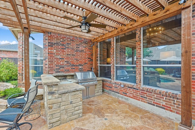 view of patio with a bar, an outdoor kitchen, ceiling fan, grilling area, and a pergola