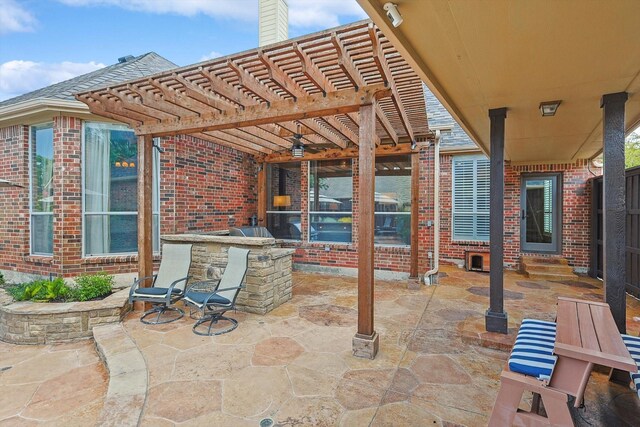 view of patio / terrace with exterior kitchen and a pergola