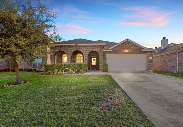 view of front of property with a yard and a garage