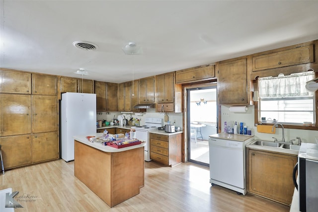 kitchen featuring a center island, light hardwood / wood-style flooring, white appliances, and sink