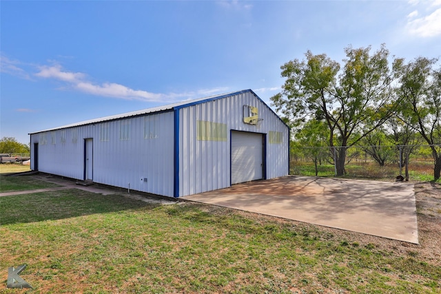 view of outdoor structure with a garage and a lawn