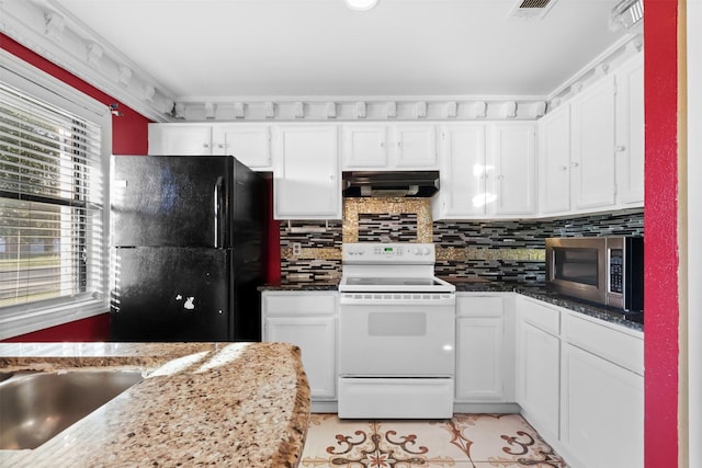 kitchen featuring black refrigerator, white range with electric cooktop, dark stone counters, and white cabinetry