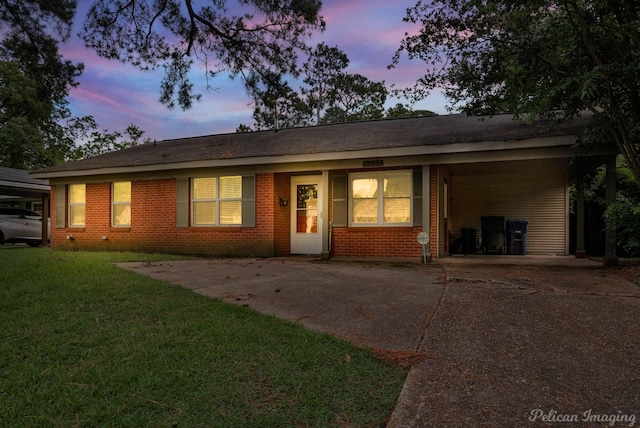 ranch-style home featuring a carport and a lawn