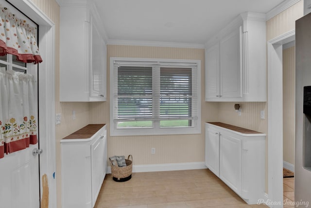 kitchen with crown molding, white cabinets, and light hardwood / wood-style flooring