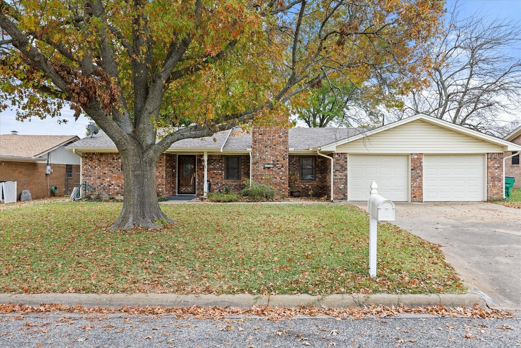 single story home featuring a garage and a front lawn