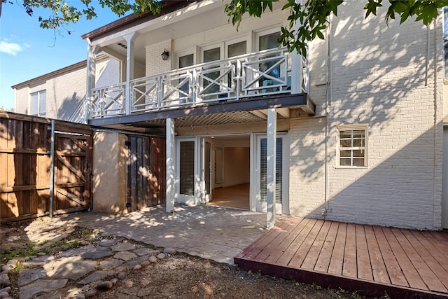 rear view of property featuring a patio and a balcony