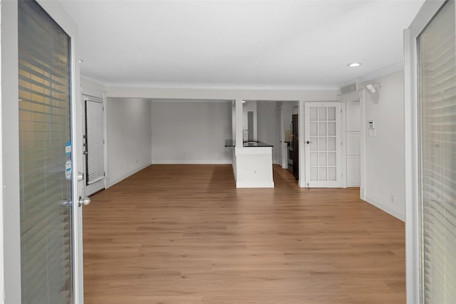 unfurnished living room with light hardwood / wood-style flooring and sink