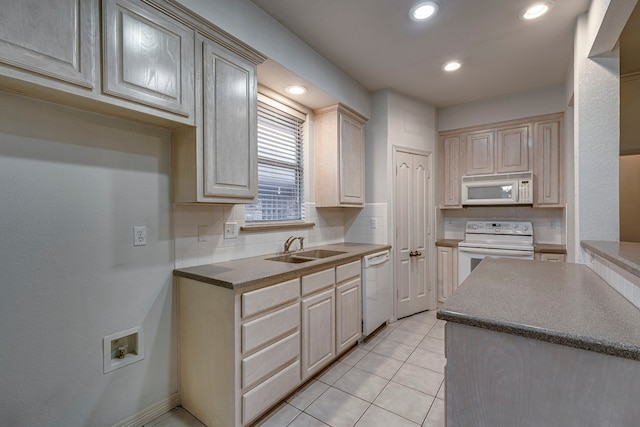 kitchen featuring tasteful backsplash, sink, light tile patterned flooring, and white appliances