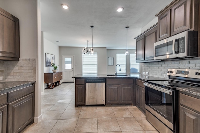 kitchen with stainless steel appliances, hanging light fixtures, a healthy amount of sunlight, and sink