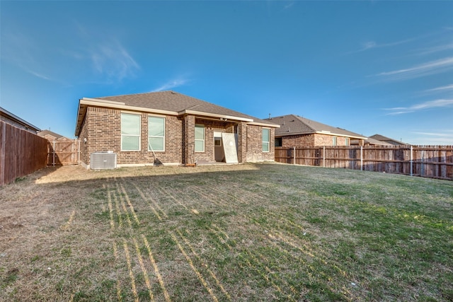 rear view of property featuring a lawn and central AC