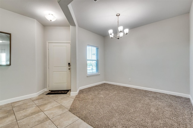 carpeted foyer entrance featuring a notable chandelier