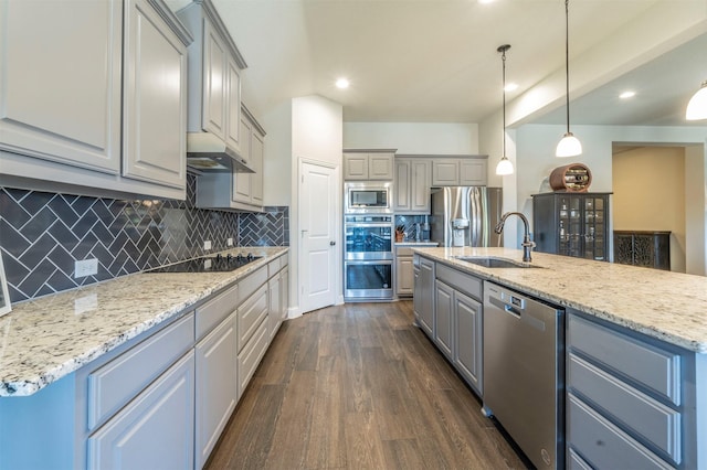 kitchen with sink, decorative light fixtures, dark hardwood / wood-style floors, an island with sink, and stainless steel appliances