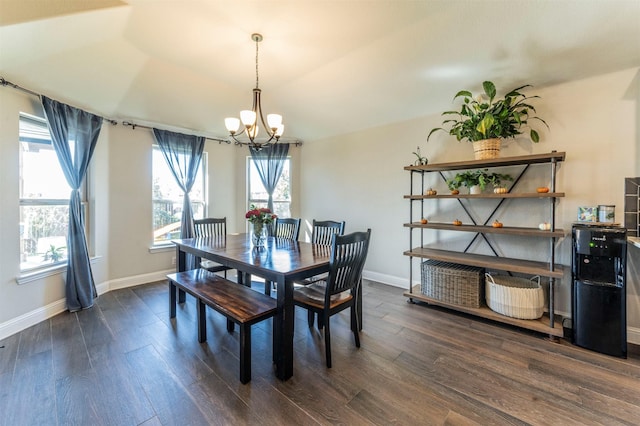 dining area with lofted ceiling, dark hardwood / wood-style floors, and a chandelier