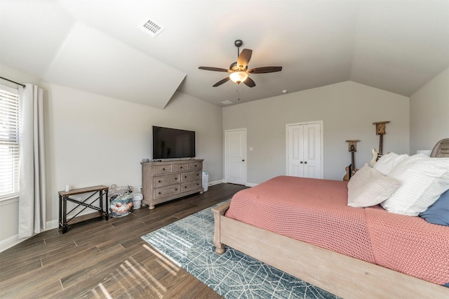 bedroom featuring lofted ceiling, dark wood-type flooring, a closet, and ceiling fan