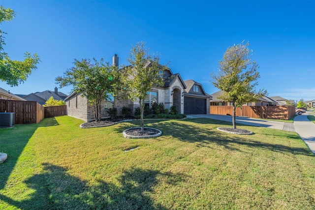 view of front of house featuring a garage, central AC, and a front yard