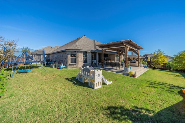 rear view of property with a trampoline, a pergola, a lawn, and a patio