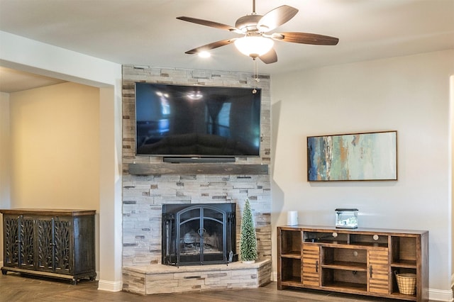 living room featuring ceiling fan, wood-type flooring, and a fireplace