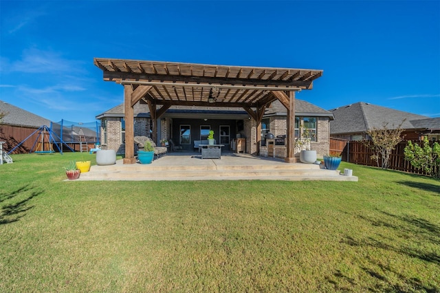 back of property featuring a yard, a patio, a trampoline, and a playground