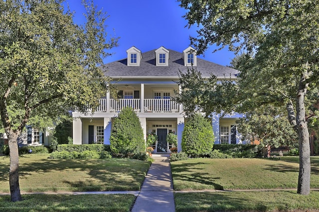 view of front facade with a front yard and a balcony