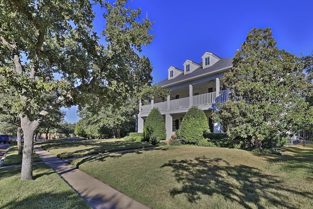 view of front of home with a balcony and a front lawn