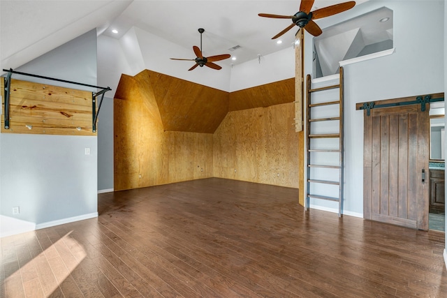 additional living space with ceiling fan, high vaulted ceiling, a barn door, recessed lighting, and wood finished floors