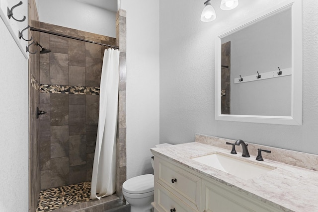 bathroom with vanity, curtained shower, and toilet