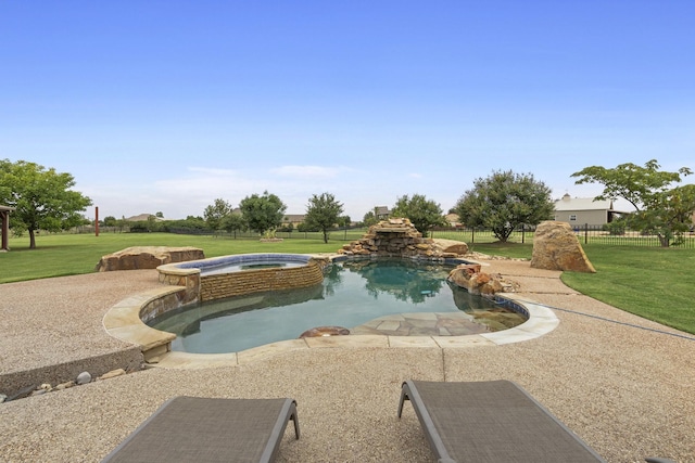 view of pool with a yard, fence, and a pool with connected hot tub