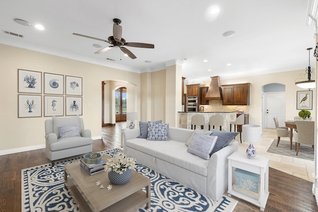 living room featuring dark hardwood / wood-style floors, ceiling fan, and ornamental molding